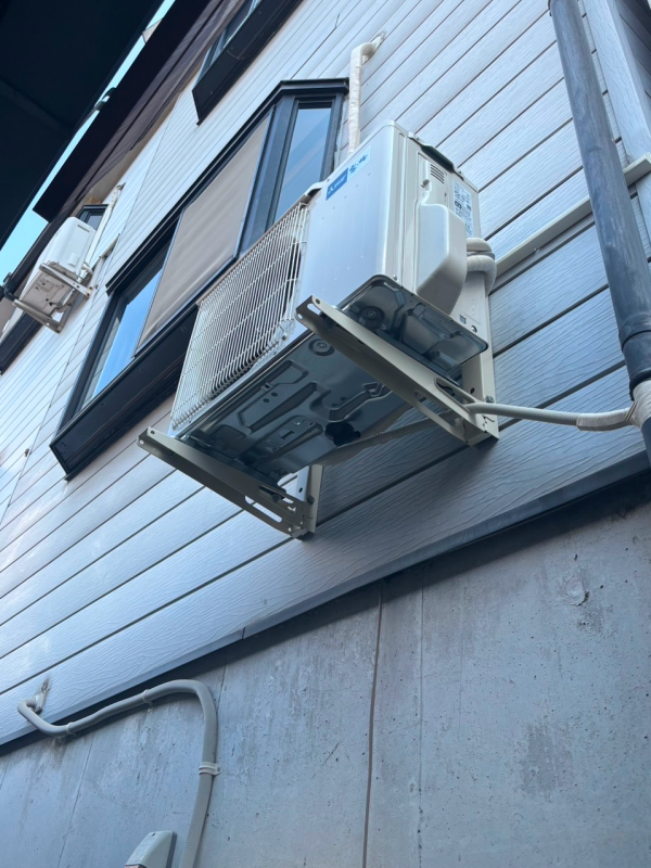 寝屋川市でエアコン設置の依頼を受け、壁面に設置した室外機